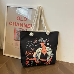 Detalle del bolso tote negro con estampado 'Black Woman' y asa de cuerda
