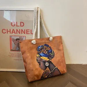 Bolso tote artístico con estampado de mujer africana y asas de cuerda gruesa.