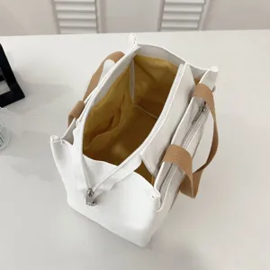 Interior view of white canvas lunch bag with yellow lining and zipper closure