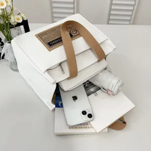 White canvas commuter tote bag showing interior storage capacity with everyday essentials