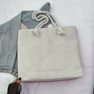 Detalle de un bolso de lona beige con asas gruesas de cuerda de algodón blanco para mujer