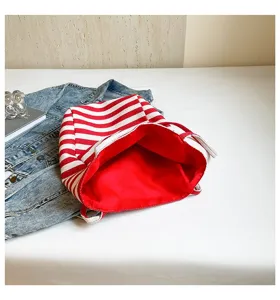 Primer plano de bolsa de lona a rayas rojas y blancas con espacioso interior rojo