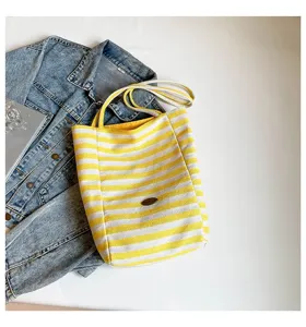 Bolso de lona a rayas amarillas y blancas de estilo informal con chaqueta vaquera blanca