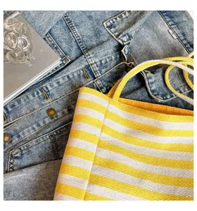 Primer plano del bolso tote de lona a rayas amarillas y blancas con textura fina