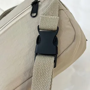 Detalle de cerca de la hebilla de plástico negro duradera y la correa de nailon ajustable del bolso