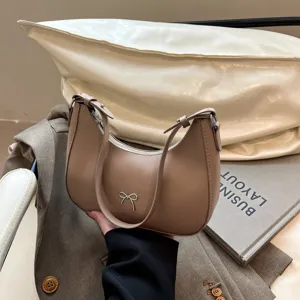 Gedetailleerd overzicht van een beige zadeltas met strik op een stijlvolle achtergrond.