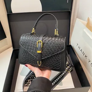Elegante bolso bandolera tejido negro en caja de regalo con una correa ancha chic.