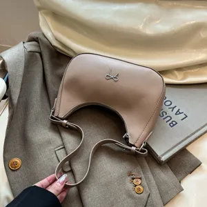 Detail van de elegante kaki hobo-tas met een verfijnde zilveren strik.