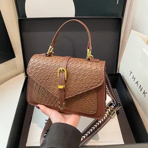 Bolso de mano marrón con textura trenzada, correa estampada y hebilla dorada de moda.