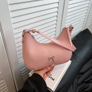 Close-up van een stijlvolle roze schoudertas met een chic zilverkleurig strikje detail
