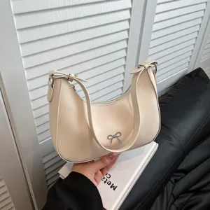 Minimalistische crème vegan lederen hobo tas met zilveren strik en schouderriem.