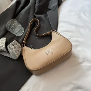 Khaki halvemaan schoudertas met metalen strik op een stijlvolle lifestyle achtergrond