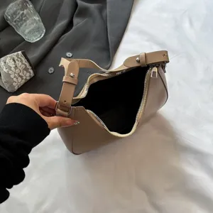Gedetailleerd overzicht van de beige hobo-tas met ritssluiting en een brede riem
