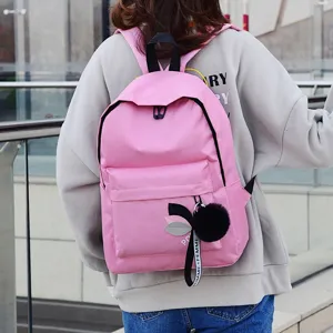 Stilvoller rosafarbener Canvas-Rucksack mit Bommel-Detail in einer Außenumgebung