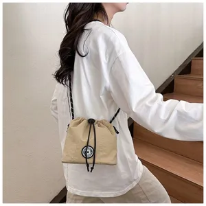 Vista dettagliata di una borsa a secchiello in nylon kaki con coulisse su un modello
