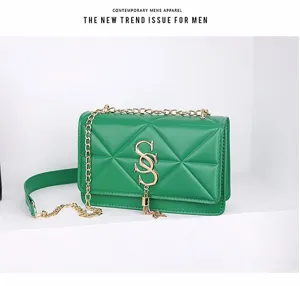 Detail van groene gewatteerde crossbodytas met gouden S-beslag en elegante ketting.