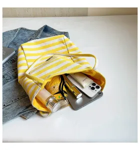 Bolso tote de lona a rayas amarillas de gran capacidad que muestra el interior amplio.
