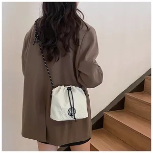 Dettaglio di un secchiello in nylon color crema con coulisse indossato da un modello