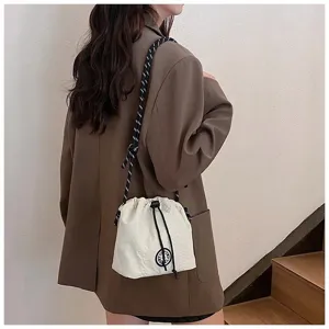 Borsa a secchiello in nylon bianco con coulisse indossata da una modella in abito casual.