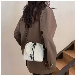 Dettaglio ravvicinato di una borsa a secchiello in nylon crema con coulisse sulla schiena