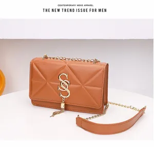 Detail van gewatteerde bruine crossbodytas met gouden SS-logo en elegante kettingriem.