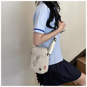 Detail van eenvoudige gebroken witte nylon crossbody tas voor mobiel in Japanse schoolmeisjesstijl