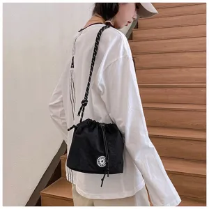 Borsa a secchiello casual in nylon nero con coulisse, indossata da una modella in ambiente