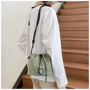 Dettaglio della borsa a secchiello casual in nylon con coulisse verde chiaro