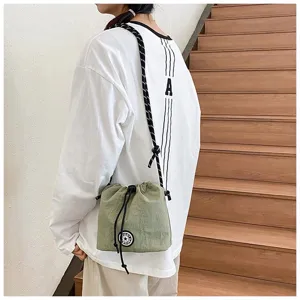 Dettaglio lifestyle di una borsa a secchiello casual in nylon verde con coulisse