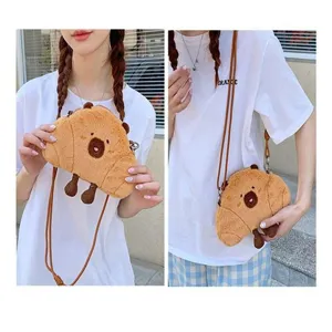 Detailed view of a cute plush Capybara croissant-shaped crossbody bag worn by a model