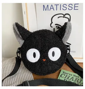 Gros plan sur un adorable sac bandoulière en peluche chat noir avec de grands yeux blancs.