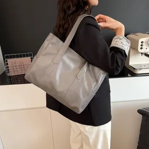Bolso tote grande gris minimalista mostrado en modelo para el trabajo