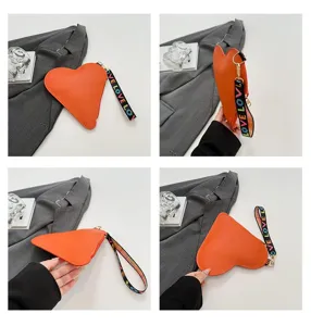 Detalle del monedero de cuero naranja en forma de corazón con correa de mano LOVE