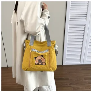 Detail view of yellow cartoon tote bag with cute capybara print and grey straps