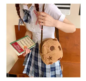 Détail du sac à bandoulière en peluche capybara marron avec une tenue d'écolière