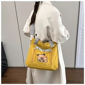 Cute yellow tote bag with cartoon capybara print and adjustable gray shoulder strap