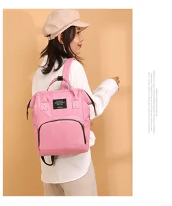 Elegante mujer asiática con una mochila para mamá rosa de gran capacidad
