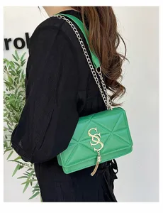 Elegante groene gewatteerde crossbodytas met gouden ketting en stijlvolle kwast.
