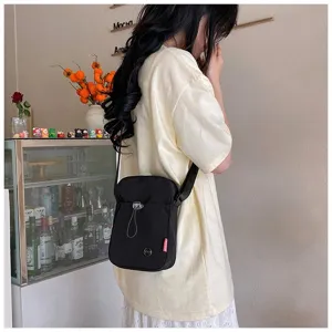 Stijlvolle zwarte nylon crossbodytas gedragen door een model in een café-setting