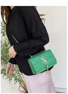 Detail van stijlvolle groene gewatteerde crossbodytas met gouden ketting en kwast