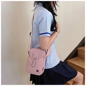 Stijlvolle roze lichtgewicht nylon crossbodytas gedragen door een Aziatisch model