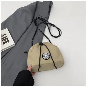 Dettaglio ravvicinato di borsa a secchiello in nylon kaki con toppa sportiva a stella