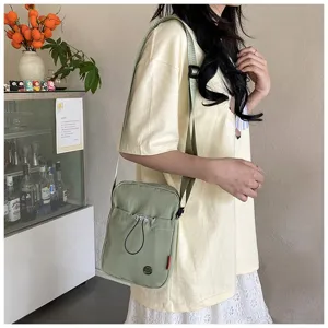 Stijlvolle lichtgroene nylon crossbodytas voor dames met voorvak getoond op model