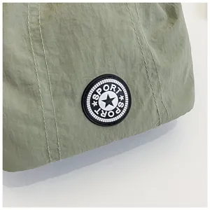 Dettaglio ravvicinato della borsa in nylon verde oliva con patch SPORT e doppie cuciture