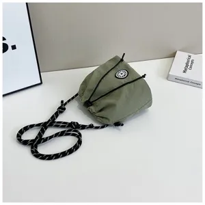 Vista dettagliata di una borsa a secchiello in nylon verde salvia con logo sportivo