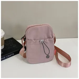 Zijaanzicht van een stijlvolle roze nylon crossbodytas met een verstelbare riem