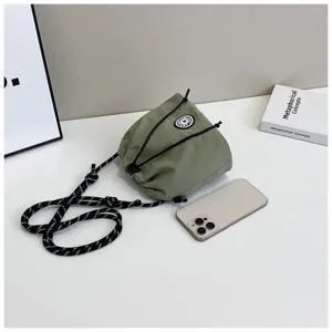 Borsa a secchiello in nylon verde con coulisse e telefono per confronto dimensioni.