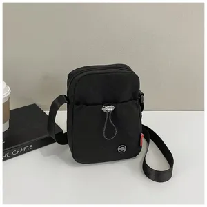 Gedetailleerde macro-opname van een minimalistische zwarte nylon crossbody-tas