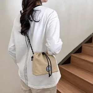 Borsa a secchiello a tracolla leggera in nylon kaki con chiusura a coulisse casuale.