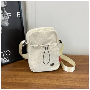 Gedetailleerd overzicht van het nylon materiaal op deze minimalistische witte crossbodytas.
